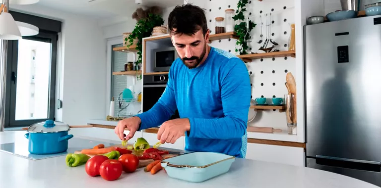Hombre preparándose la comida a base de vegetales