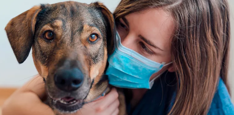 Chica con mascarilla junto a su perro