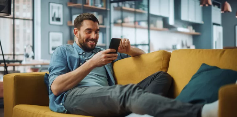 Hombre joven sentado viendo su smartphone