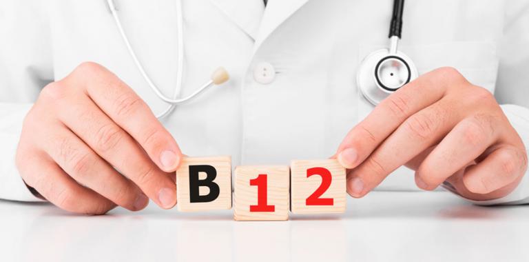 Un médico sosteniendo en las manos unos cubos de madera con las letras B12