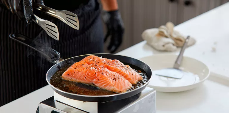 Cocinero preparando salmón a la plancha