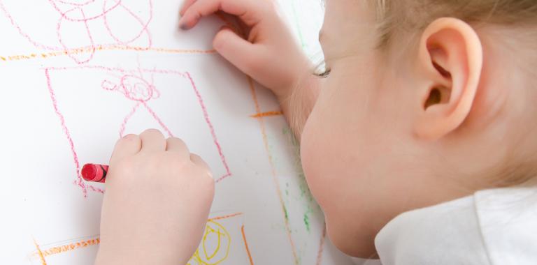 Niño dibujando con la mano izquierda
