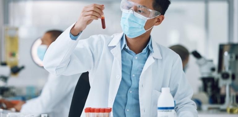 Investigador sostiene un tubo con sangre en un laboratorio