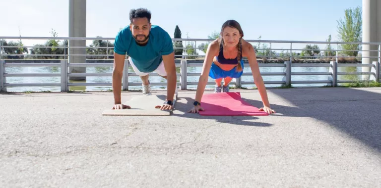 pareja joven realizan burpees en su entrenamiento de fuerza