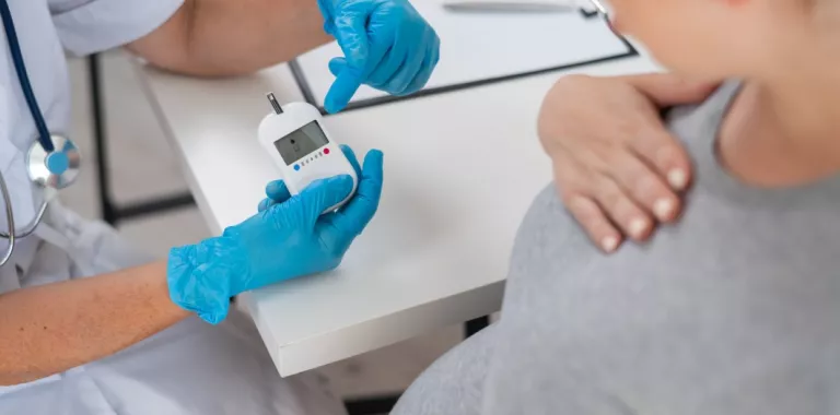 Doctora comprueba los niveles de azúcar en sangre de una embarazada