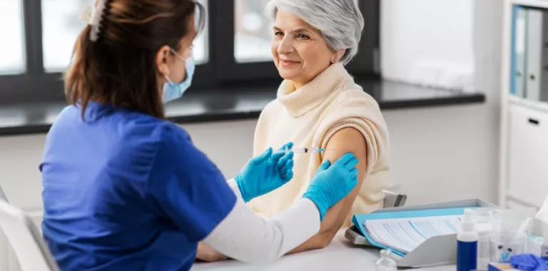Sanitaria pone una vacuna a una mujer mayor