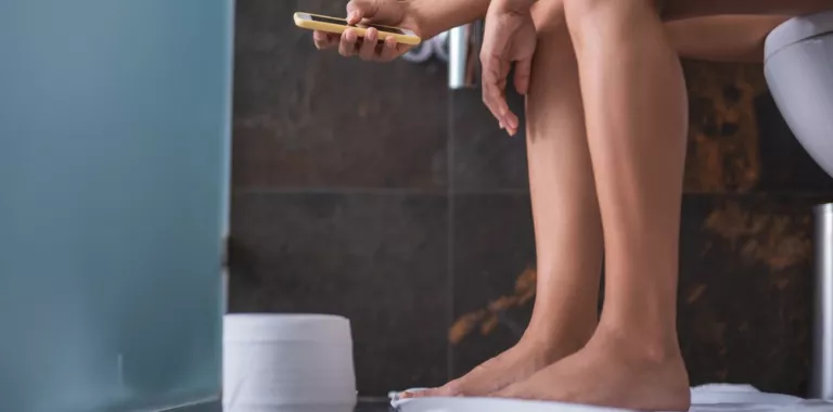 Uso del teléfono inteligente en la taza del baño
