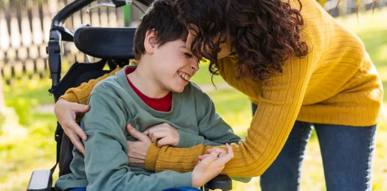 Mujer atiende a su hijo en silla de ruedas
