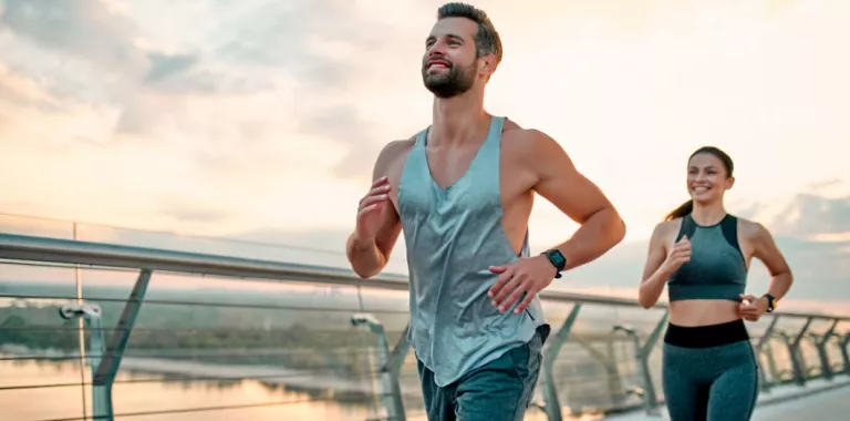 Un hombre y una mujer corren al aire libre para hacer ejercicio