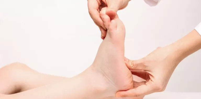 Doctora examina el pie de un niño para comprobar si presenta pie plano Un médico examina la planta del pie de un niño