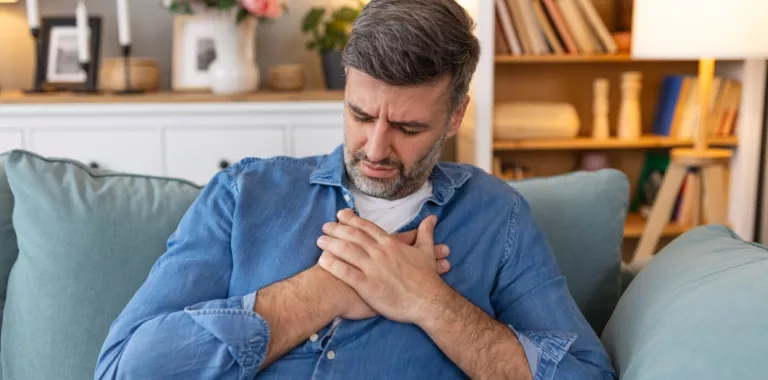 Hombre con gesto de dolor apoya sus manos sobre el corazón Hombre con las manos sobre el pecho con gesto de dolor