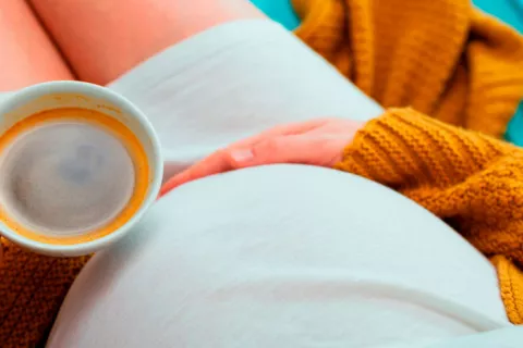Mujer embarazada tomando café