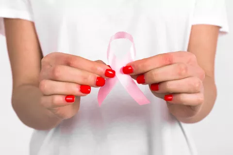 Mujer con el lazo representativo del cáncer de mama