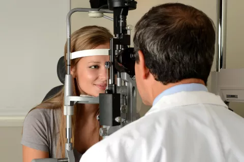 Un oftalmólogo examina los ojos de una mujer embarazada