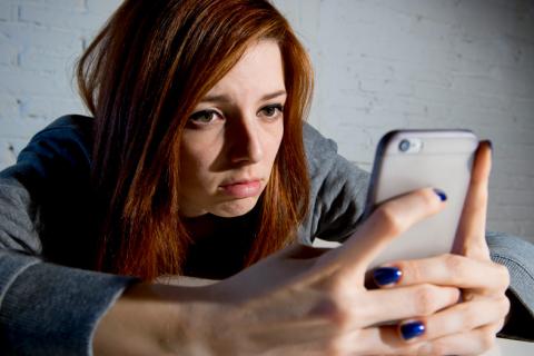 Chica con síntomas de estrés por su adicción al móvil 