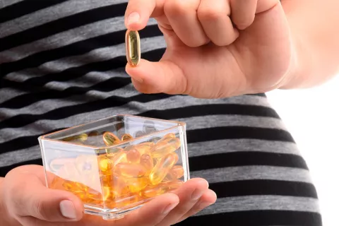 Mujer embarazada tomando omega 3