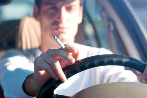 Hombre fumando en el coche