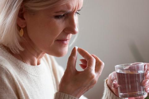 Mujer tomando fármacos para mejora los síntomas de la menopausia