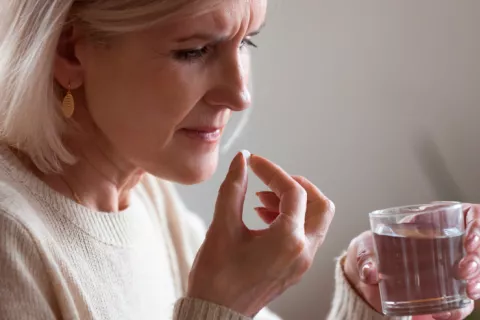 Mujer tomando fármacos para mejora los síntomas de la menopausia