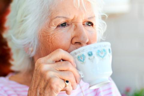 Mujer tomando tazas de té para mejorar la salud cerebral