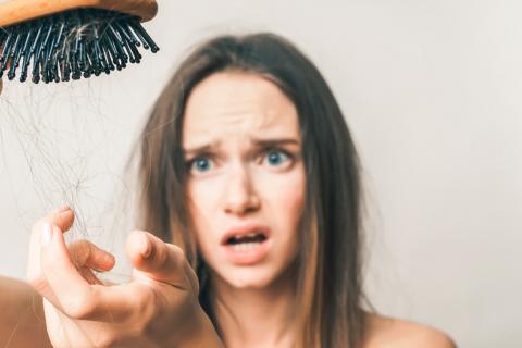 Mujer sufriendo la pérdida de cabello 