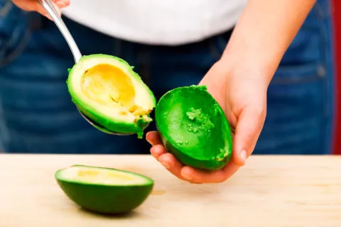 Mujer con un aguacate para prevenir la obesidad 