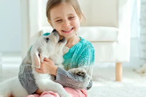 Crecer con un perro ayuda al desarrollo social y emocional del niño Niña con su mascota en casa