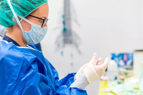 Una enfermera se pone guantes protectores