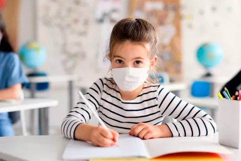 Grupo de niños con mascarilla en el colegio