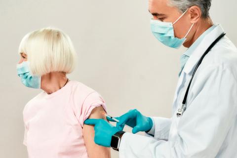 Doctor vacunando a una mujer mayor contra el Covid-19