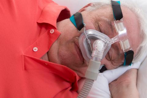 Hombre mayor con apnea para dormir y máquina CPAP