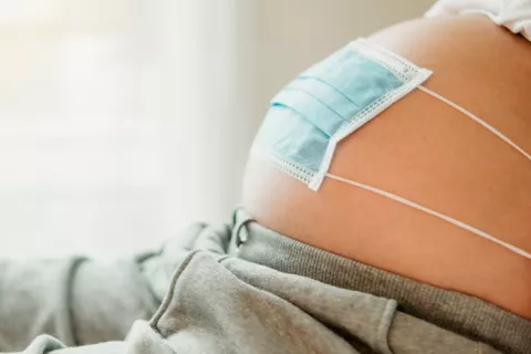 Las embarazadas con COVID-19 transfieren pocos anticuerpos a sus bebés Embarazada cubriendo su vientre con una mascarilla