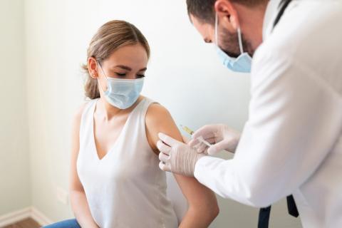 Enfermero vacuna de COVID-19 a una mujer adulta en España