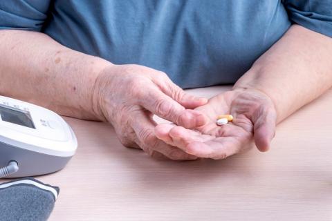 Mujer anciana tomando sus pastillas para controlar la tensión