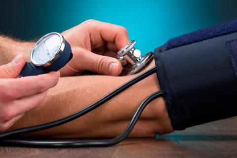 Médico controlando la presión arterial a un paciente