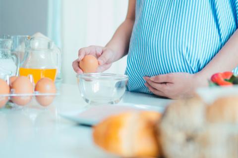 Mujer embarazada tomando yemas de huevo