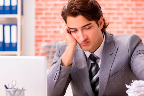 Falta de memoria y concentración en 70% afectados por COVID persistente Persona en la oficina con signos de poca concentración