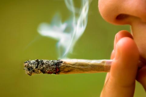 Mujer joven fumando un &#039;porro&#039; de marihuana