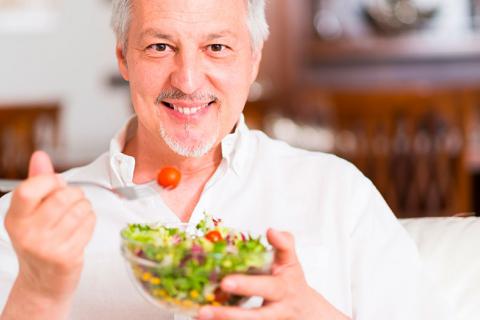 Hombre comiendo un plato de verdura