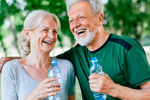 Una pareja mayor haciendo ejercicio y bebiendo agua