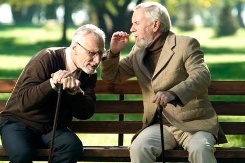 Dos ancianos sentados en un banco hablando