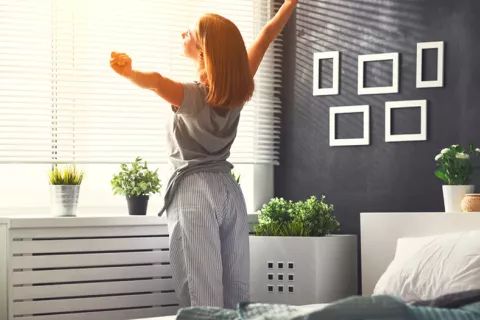 Hábitos de vida saludables reducen el riesgo de COVID persistente Mujer estirándose en la cama