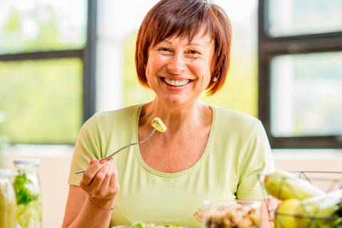 Retrato de una mujer mayor con comida saludable en la mesa