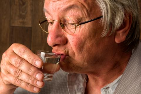 Un hombre mayor bebiendo alcohol