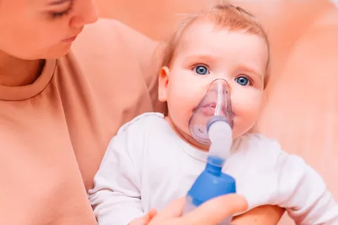 Infección respiratoria con 2 años eleva el riesgo de muerte de adulto Bebé con una máscara inhaladora