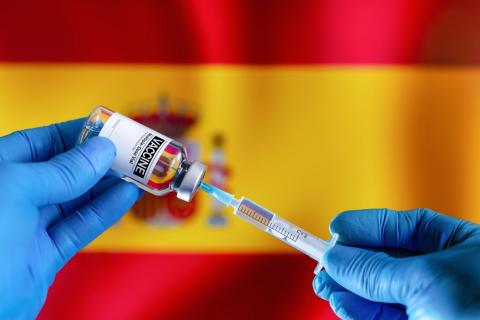 Imagen de vacuna COVID sobre bandera de España