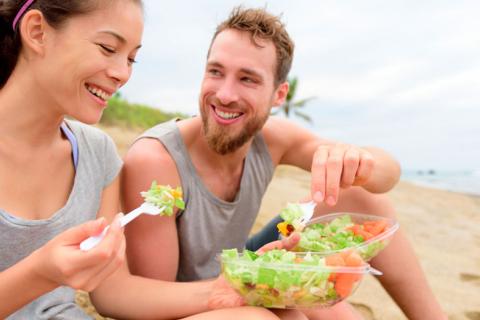 Dos jóvenes comiendo una ensalada saludable