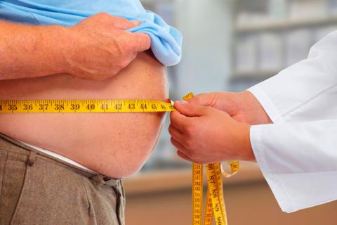 Médico midiendo el perímetro abdominal de un varón obeso