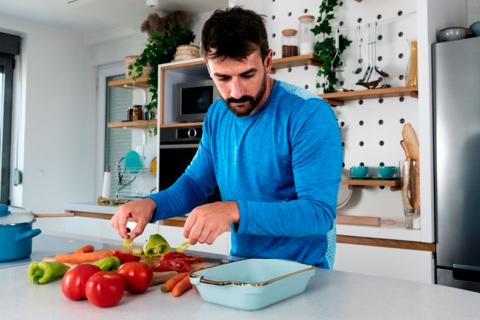 Hombre preparándose la comida a base de vegetales