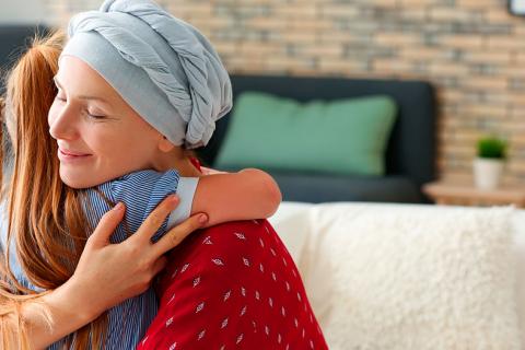 Una madre que padece de cáncer con su hija, que se abrazan con alivio 
